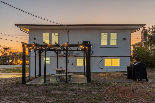 rear view of property with a patio area, a pergola, and stucco siding