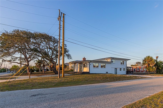 view of front of home with a front lawn, a chimney, and stucco siding