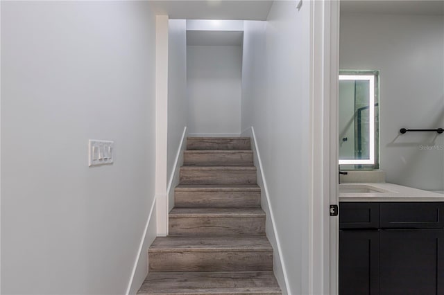 staircase with baseboards and wood finished floors