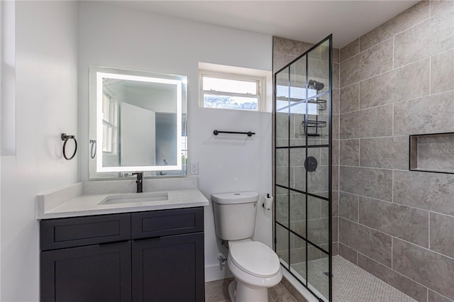 bathroom featuring a walk in shower, toilet, and vanity