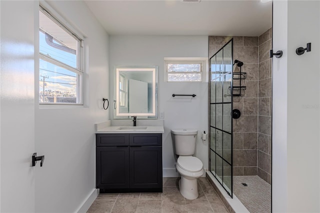 full bathroom featuring toilet, a shower stall, vanity, tile patterned flooring, and baseboards