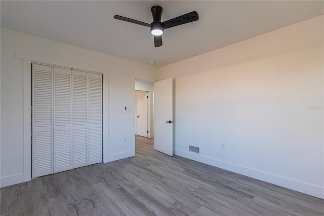 unfurnished bedroom featuring light wood-style floors, a closet, visible vents, and baseboards