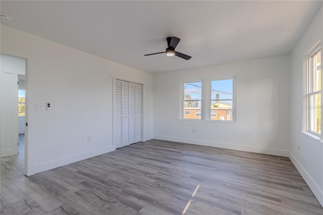 unfurnished bedroom featuring light wood finished floors, baseboards, and a ceiling fan