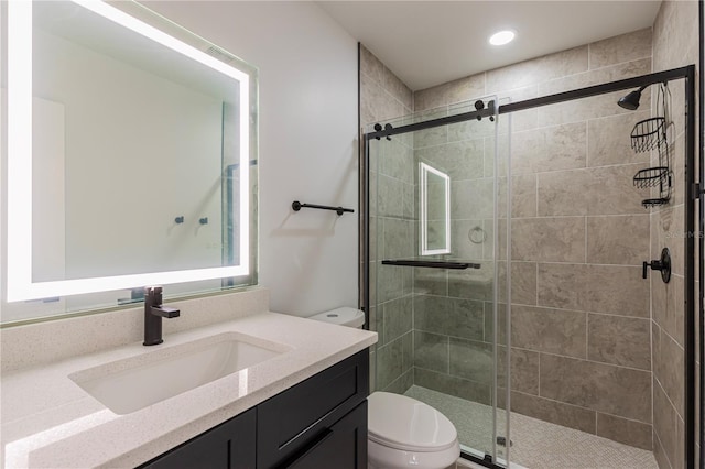 full bath featuring a stall shower, vanity, and toilet