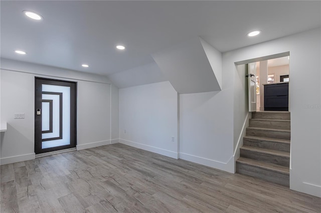 interior space with recessed lighting, stairway, light wood-style floors, vaulted ceiling, and baseboards