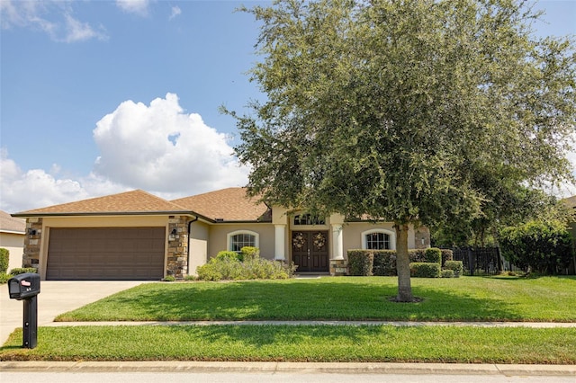 view of front of property featuring driveway, an attached garage, stucco siding, a front lawn, and stone siding