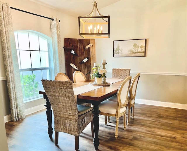 dining room with a notable chandelier, wood finished floors, and baseboards