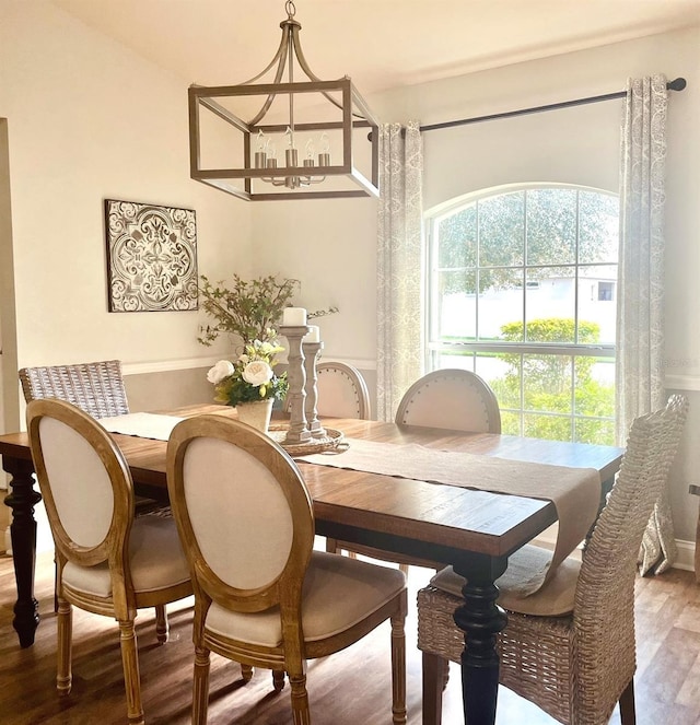 dining area with a notable chandelier and wood finished floors