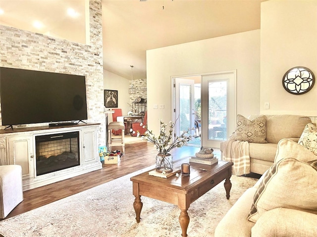 living room featuring a ceiling fan, high vaulted ceiling, wood finished floors, and a fireplace