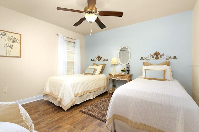 bedroom featuring ceiling fan, baseboards, and wood finished floors