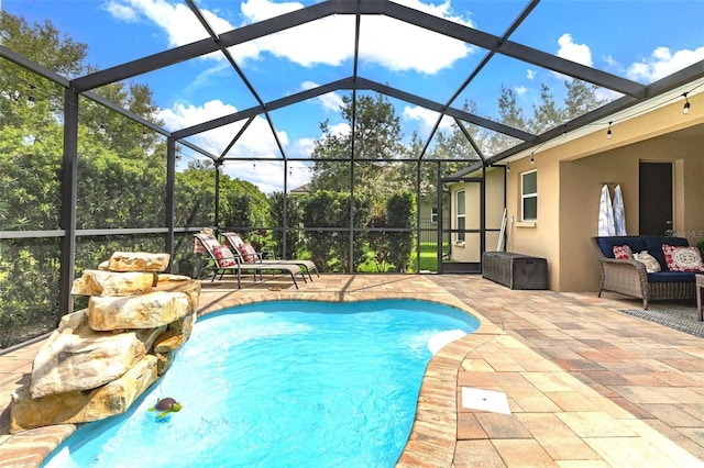 pool with glass enclosure, a patio, and outdoor lounge area