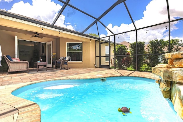 outdoor pool with a patio area, glass enclosure, an outdoor hangout area, and ceiling fan