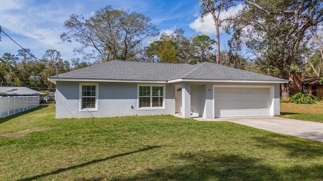 ranch-style house with a garage, fence, driveway, stucco siding, and a front yard