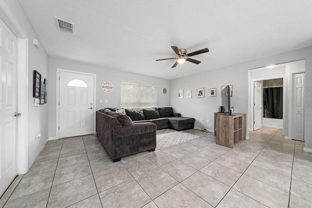 living room with visible vents, ceiling fan, baseboards, and light tile patterned flooring