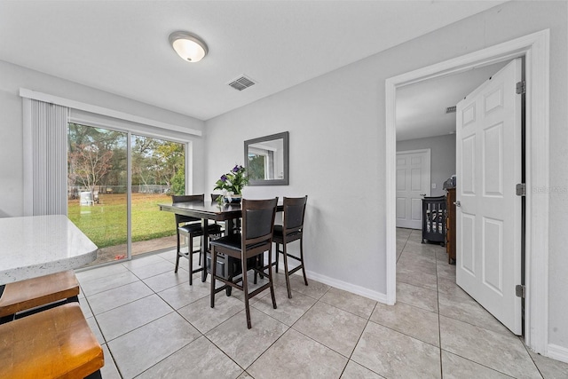 dining space featuring light tile patterned floors, baseboards, and visible vents