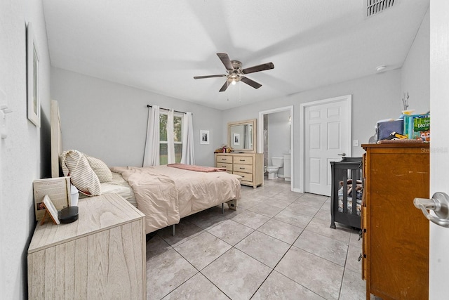 bedroom with a ceiling fan, visible vents, ensuite bathroom, and light tile patterned floors