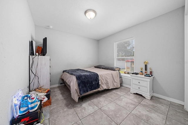 bedroom featuring light tile patterned floors and baseboards