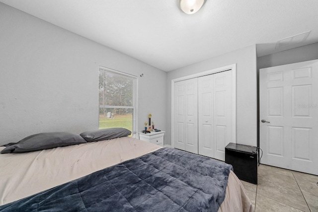 bedroom featuring a closet and light tile patterned floors