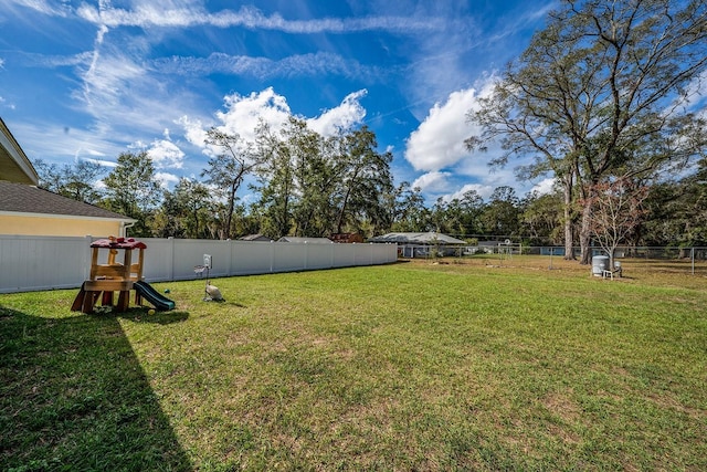 view of yard featuring a playground and a fenced backyard