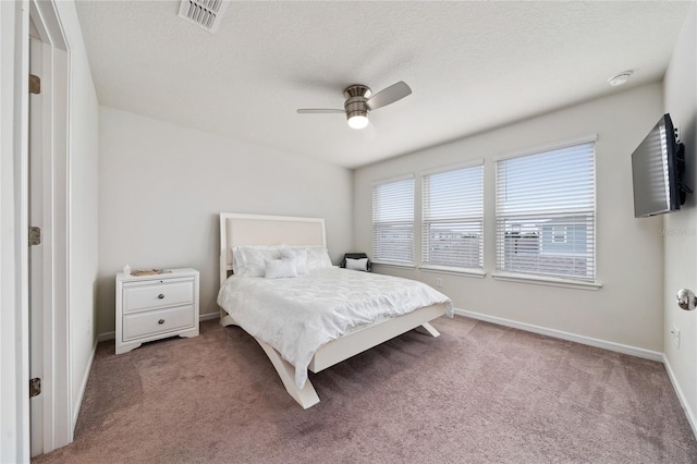 bedroom with baseboards, a textured ceiling, visible vents, and carpet flooring