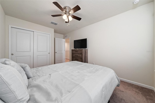 bedroom with baseboards, visible vents, ceiling fan, carpet floors, and a closet