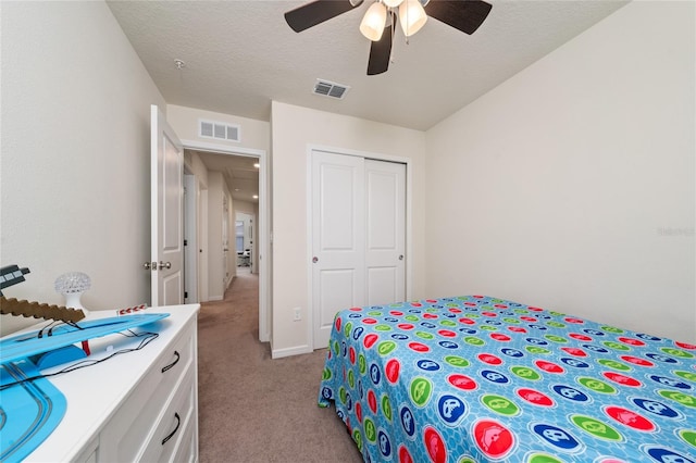 bedroom featuring a textured ceiling, a closet, visible vents, and light colored carpet