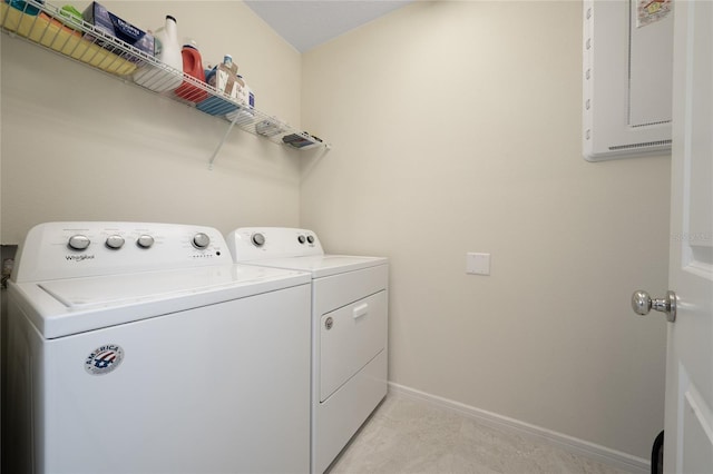 clothes washing area featuring laundry area, baseboards, and washing machine and clothes dryer