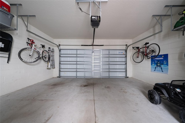 garage with concrete block wall and a garage door opener