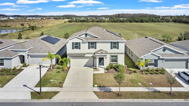 view of front facade with a water view, driveway, and stucco siding