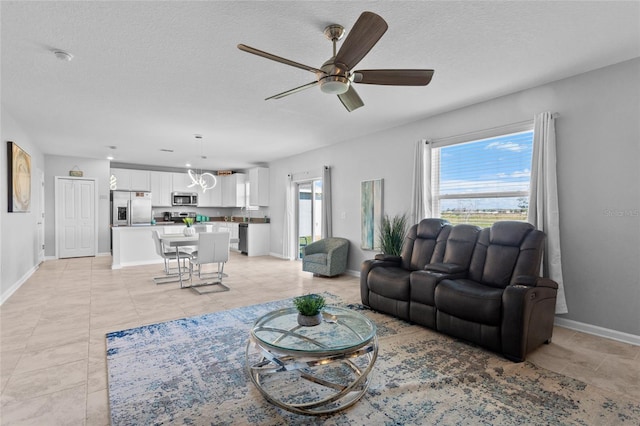 living area with baseboards, a textured ceiling, and light tile patterned flooring