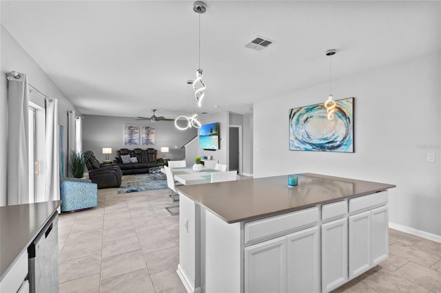 kitchen with a kitchen island, visible vents, white cabinetry, open floor plan, and dark countertops