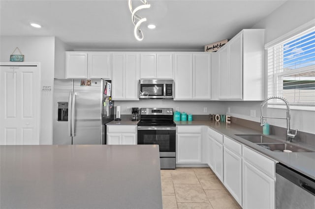 kitchen featuring white cabinetry, stainless steel appliances, and a sink