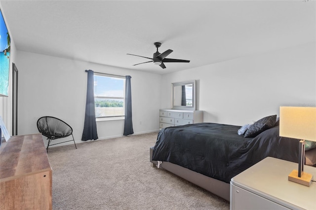 bedroom featuring a ceiling fan, light carpet, and baseboards