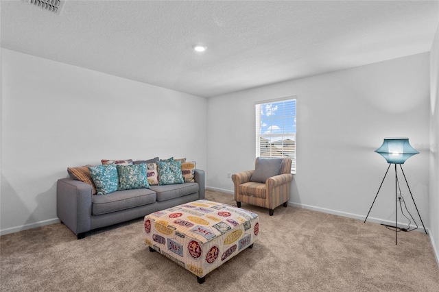 living area with a textured ceiling, carpet flooring, visible vents, and baseboards