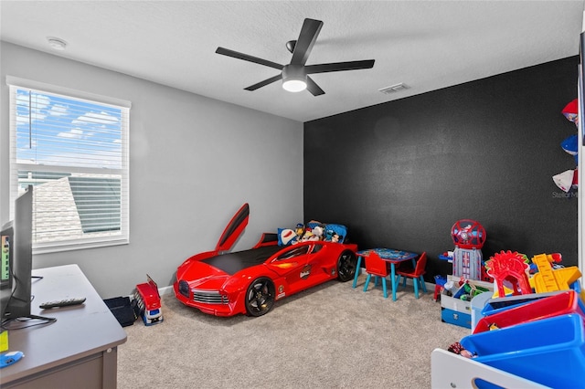 carpeted bedroom with ceiling fan, visible vents, and a textured ceiling