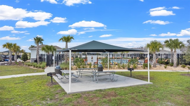 view of property's community with a patio, a lawn, and fence