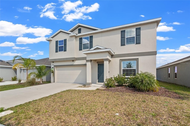 traditional home featuring a front yard, driveway, an attached garage, and stucco siding