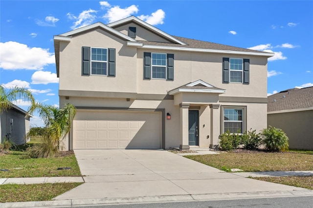 traditional home with a garage, concrete driveway, and stucco siding