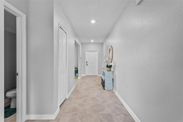 hallway featuring recessed lighting and baseboards