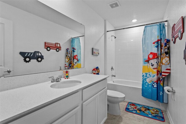 bathroom featuring toilet, vanity, visible vents, tile patterned floors, and shower / bathtub combination with curtain