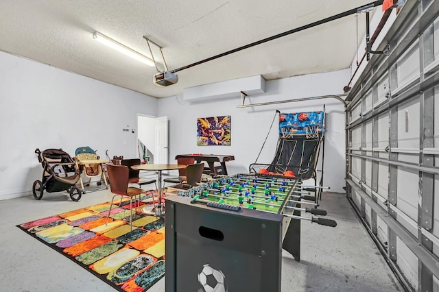 game room with a garage, a textured ceiling, and concrete flooring