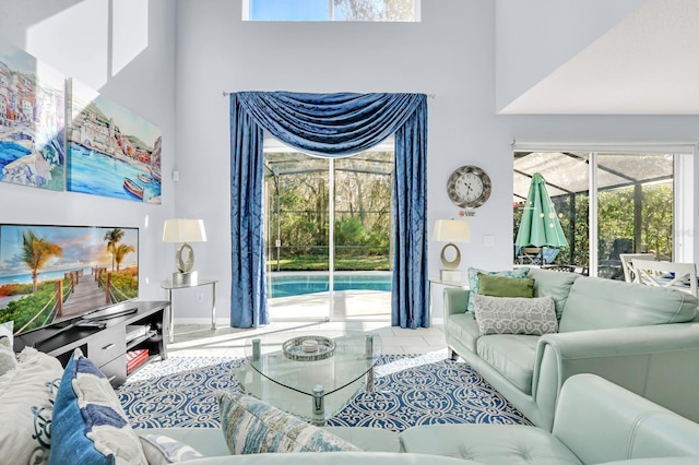 tiled living area featuring a sunroom and a towering ceiling