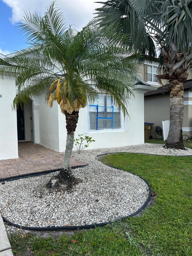 view of side of property with a lawn and stucco siding