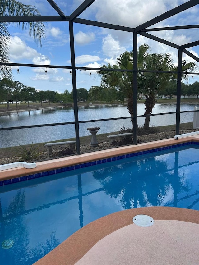 pool featuring glass enclosure and a water view