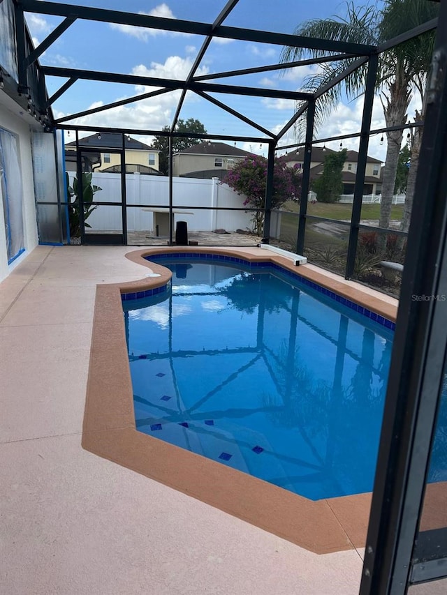 view of pool with glass enclosure, a patio, and a fenced in pool