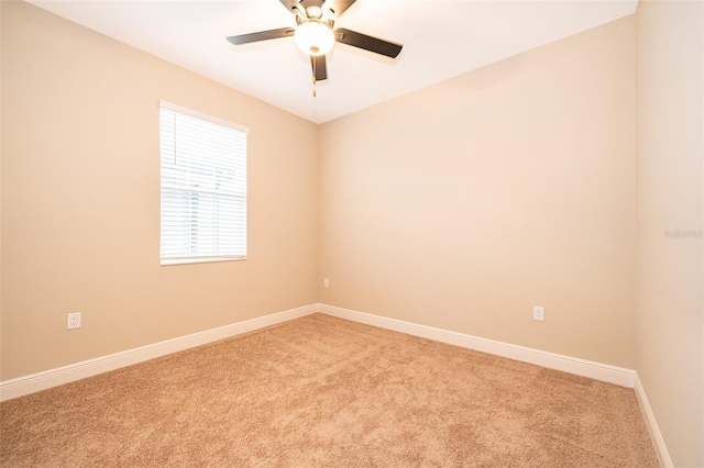 spare room with light colored carpet, ceiling fan, and baseboards