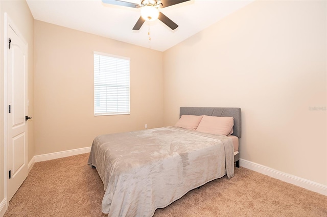 bedroom with light carpet, baseboards, and a ceiling fan