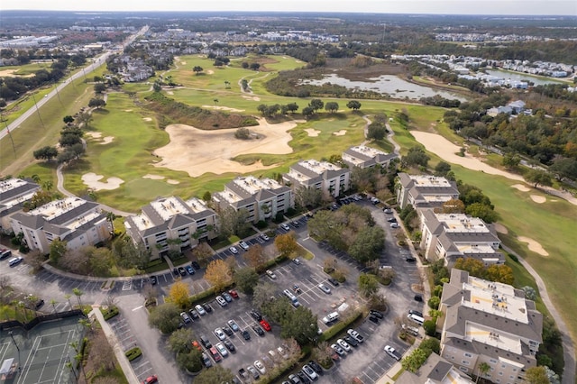 drone / aerial view with view of golf course and a water view