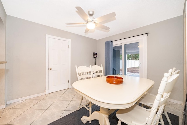 dining space featuring light tile patterned floors, a ceiling fan, and baseboards