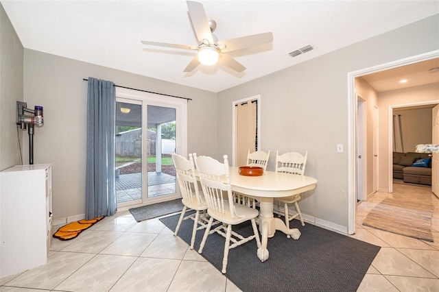 dining room with light tile patterned floors, baseboards, visible vents, and a ceiling fan